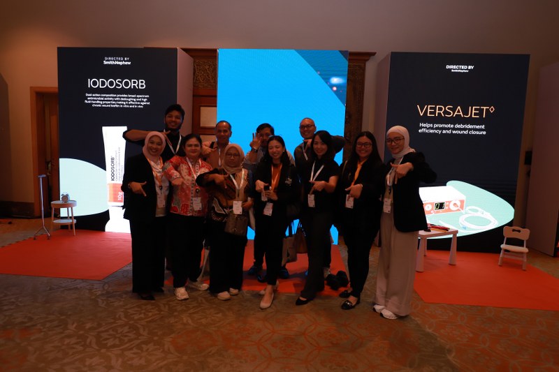 Group photo at the IODOSORB and VERSAJET exhibition backdrop, Smith+Nephew Academy conference Bangkok